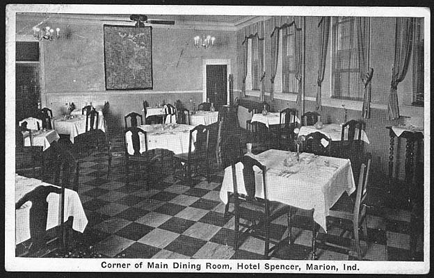 (ca. 1930s) Corner of main dining room, Hotel Spencer, Marion, IN, shows tables set for dinner, ceiling fan, light fixtures, windows with draperies