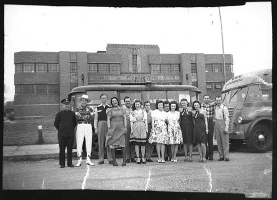 People and buses in front of the Armory during the 1940s