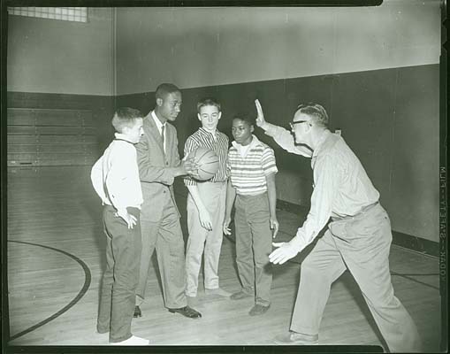 Oatess Archey & Dr. William Clary of McCulloch School showing 3 boys, Ben Alvarez, Gary Real & Tom Cox, some basketball moves. Photo was made for Equal Opportunity Week., Nov. 17, 1960.